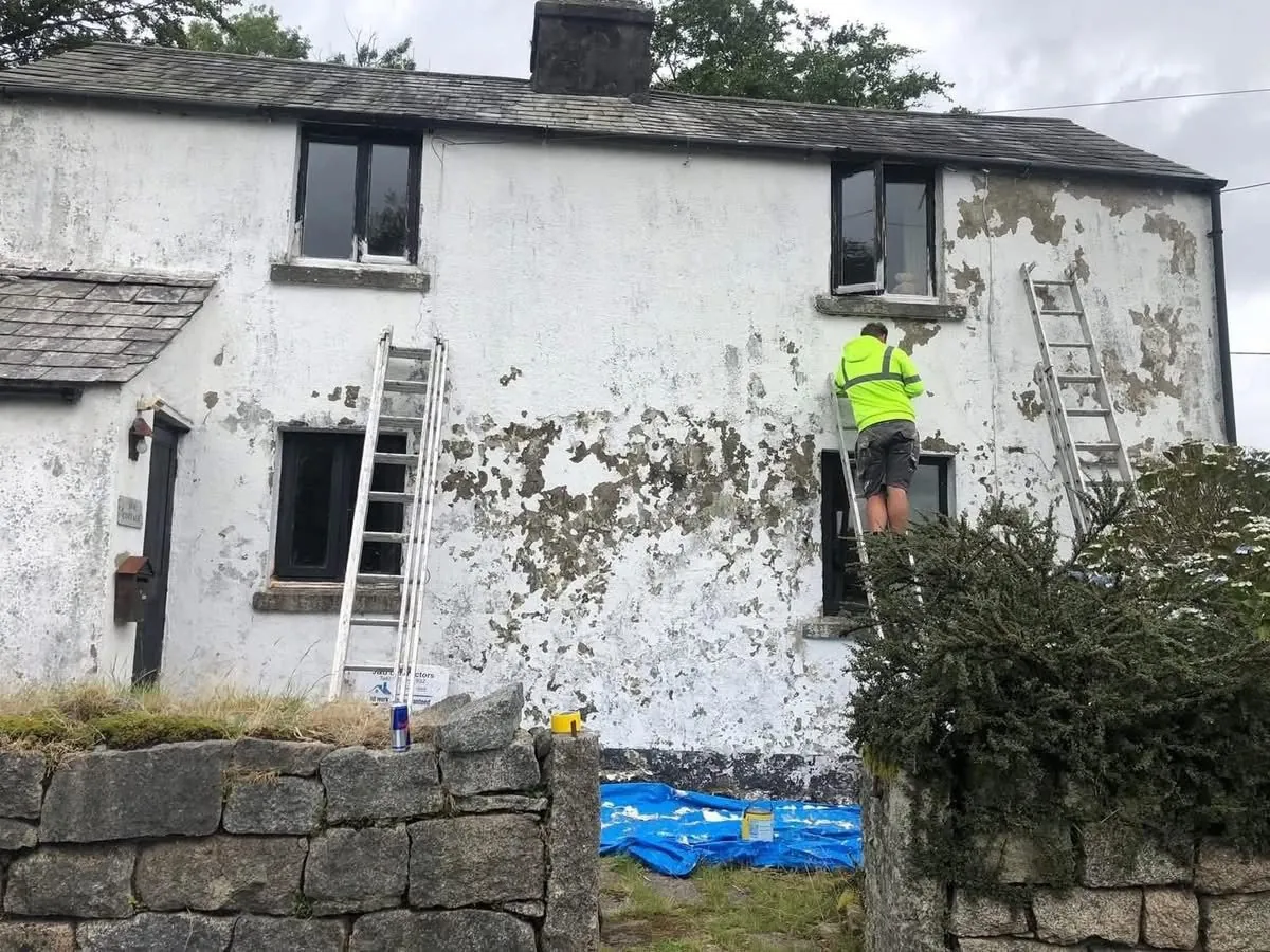 Cottage with blown, flaking render before repair in Torquay